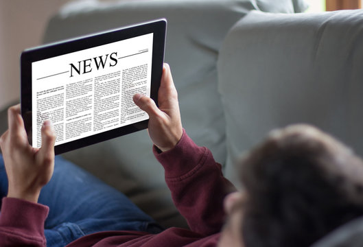 Young man reading news in a digital tablet