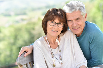 Senior couple with eyeglasses sitting outside