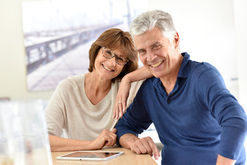 Obraz premium Senior couple at home using digital tablet