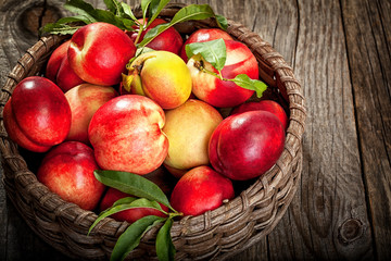 Fresh organic peaches in wooden basket with copy space