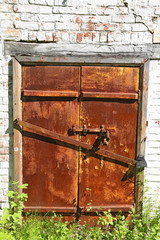Old iron closed door  on  brick wall.