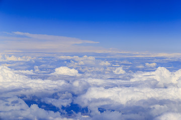 Big white clouds at blue sky view from the airplane seat