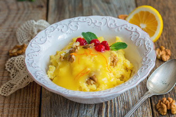 Bowl with millet porridge, lemon cream and nuts.