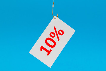 Preisschild am Haken vor blauem Hintergrund