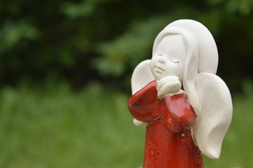 Statuette, figurine: beautiful angel with folded hands under the cheek, red robe, red dress