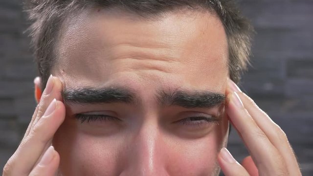 Young adult man Holding his head because of head pain.