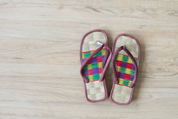 Thai local cozy weave sandal on wooden floor. slipper at home feel comfortable relax. knolling concept.
