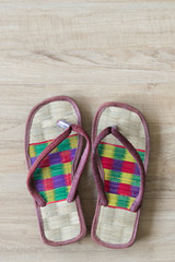 Thai local cozy weave sandal on wooden floor. slipper at home feel comfortable relax. knolling concept.