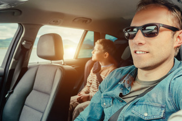 Father with son sit in car