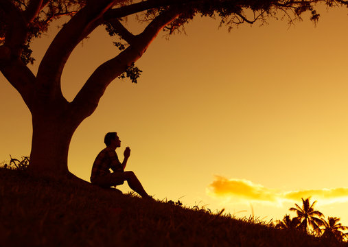 Man praying, meditating in harmony and peace at sunset

