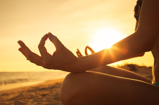 Woman doing yoga on the beach. Relax the mind.