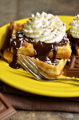 Homemade waffles with chocolate and whipped cream.