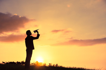 Fototapeta premium Imagination and goals concept. Silhouette man throwing paper plane