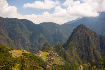Wide angle panoramic view of Machu Picchu, illuminated by afternoon sunlight, and the majestic Urubamba Valley from the Inca Trail to the Sun Gate.