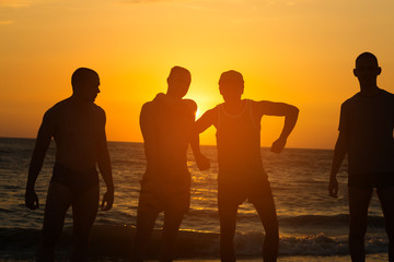 Group of people on the beach at sunset time