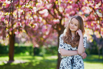 Beautiful young woman in blooming spring park