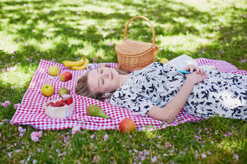 Beautiful young woman having picnic in park