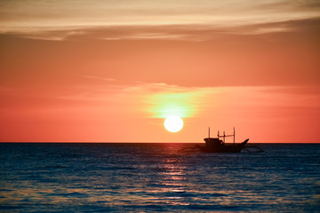 Naklejka na ściany i meble Sunset in Boracay, Philippines with a boat in the foreground