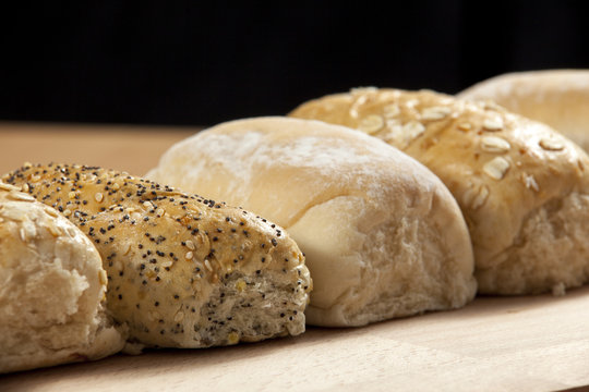 Row of freshly baked seeded wholegrain bread rolls