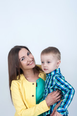 Boy in shirt sitting with mom on light background
