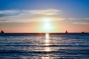 Sunset in Boracay, Philippines with people and some boats 