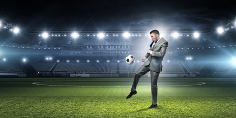 Businessman kicking ball