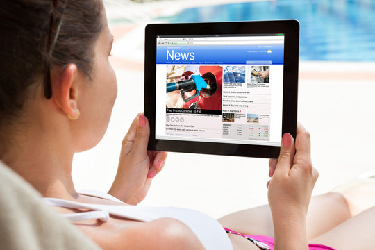 Woman Reading News On Digital Tablet