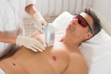 Beautician Giving Laser Epilation Treatment To Man