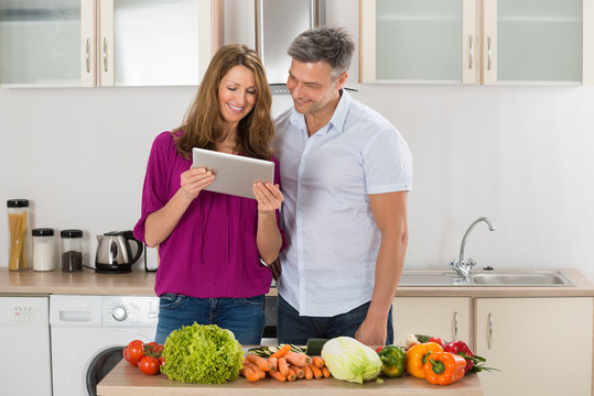 Couple Looking At Recipe On Digital Tablet