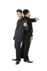 young businessmen standing back to back with thumbs up