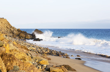 Fototapeta na wymiar Beach landscape in Malibu. The ocean and waves during strong winds in United States, California. Waves breaking on the rocks. 