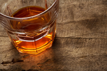 Glass of scotch whiskey on a wooden background
