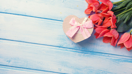Fresh coral tulips   and box with present in form of heart