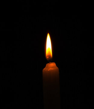 burning candle flame on black background