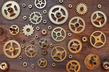Mechanical cogs gears wheels on wooden background