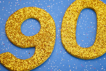 Number ninety yellow color over a blue background. Anniversary
