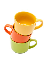 Three colorful ceramic cups with handles, yellow,orange, green