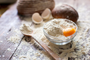 Bowl of flour with egg and bread