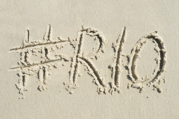 Hashtag social media message for Rio written in smooth sand on the beach in Rio de Janeiro, Brazil