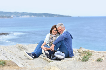 Fototapeta premium Senior couple on rambling day sitting by cliff