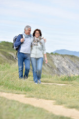 Fototapeta premium Senior couple walking by sea cliff