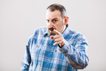 Studio shot portrait of angry man pointing