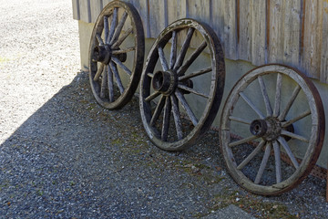 old wooden cart wheel in a garden 