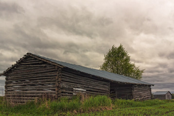 Obraz premium Two Barn Houses Under The Storm Clouds