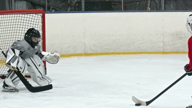 Child hockey player attacking net of opposing team and scoring goal