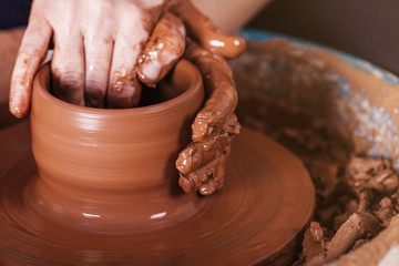Men's hands. Potter at work. Creating dishes. Potter's wheel. Di