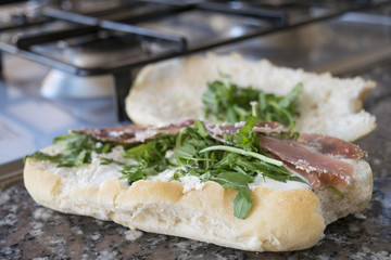 bread roll with arugula bresaola and parmesan cheese