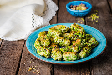 Maamoul - arabic cookies with pistachio in metal bowl on vintage wooden table background. Selective focus