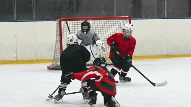 Mite hockey team scoring goal into the net of opposing team in slow motion