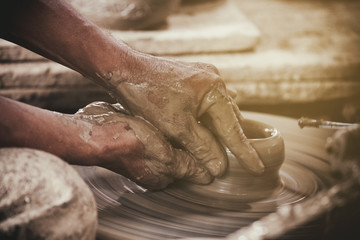 Potter makes on the pottery wheel clay pot. - obrazy, fototapety, plakaty